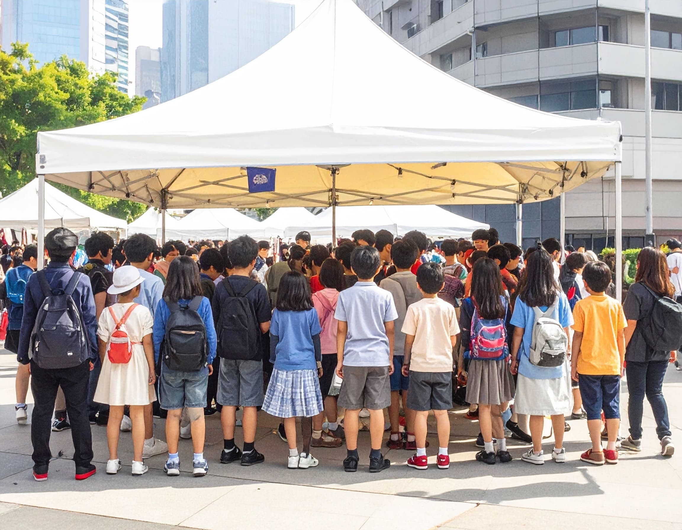 屋外イベント会場のテント前に集まる大勢の来場者